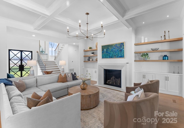 living room with a notable chandelier, coffered ceiling, built in features, and light wood-type flooring