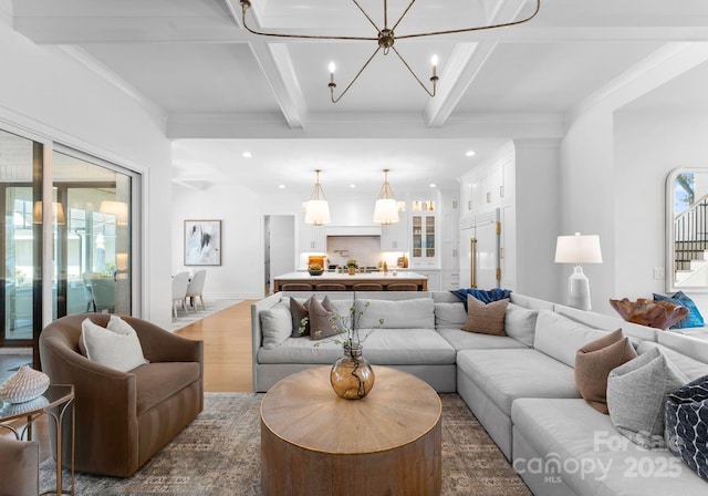 living room with coffered ceiling, a notable chandelier, ornamental molding, dark hardwood / wood-style flooring, and beamed ceiling