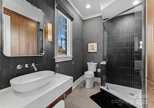 bathroom featuring vanity, toilet, tile patterned flooring, and a shower with door