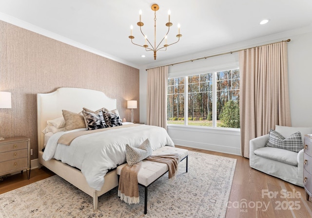 bedroom featuring an inviting chandelier, ornamental molding, and wood-type flooring