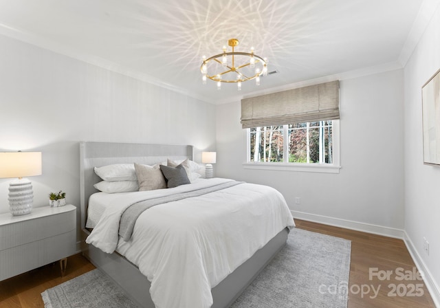 bedroom featuring dark hardwood / wood-style flooring, a notable chandelier, and ornamental molding