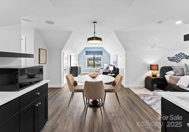 dining area with lofted ceiling and dark hardwood / wood-style flooring