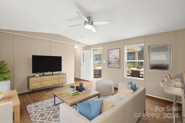 living room featuring wood-type flooring, vaulted ceiling, and ceiling fan