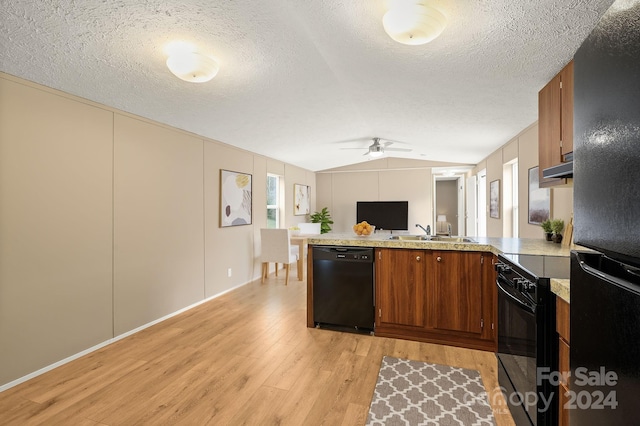 kitchen featuring kitchen peninsula, ceiling fan, sink, black appliances, and light hardwood / wood-style flooring