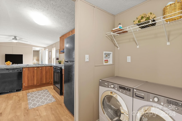 washroom featuring wooden walls, light hardwood / wood-style flooring, ceiling fan, independent washer and dryer, and a textured ceiling