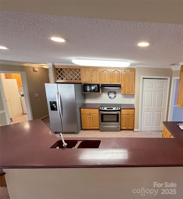 kitchen with washer / dryer, sink, a textured ceiling, and appliances with stainless steel finishes