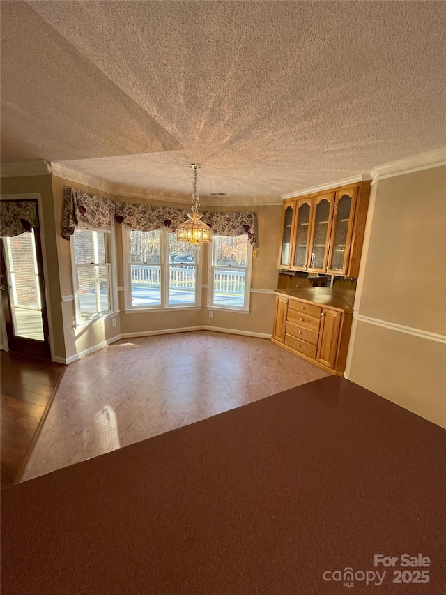 unfurnished living room with a wealth of natural light, crown molding, a textured ceiling, and a notable chandelier