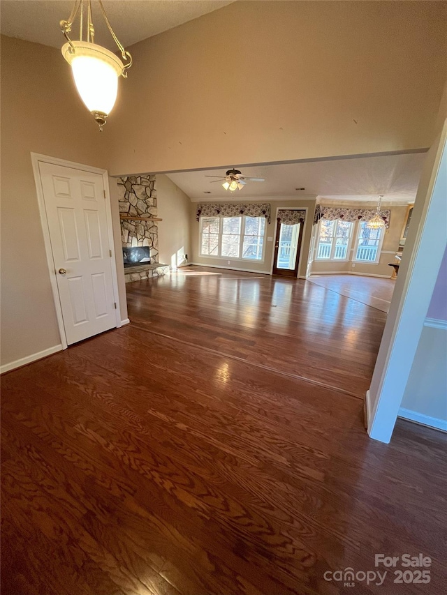 unfurnished living room with a fireplace, dark hardwood / wood-style flooring, and ceiling fan