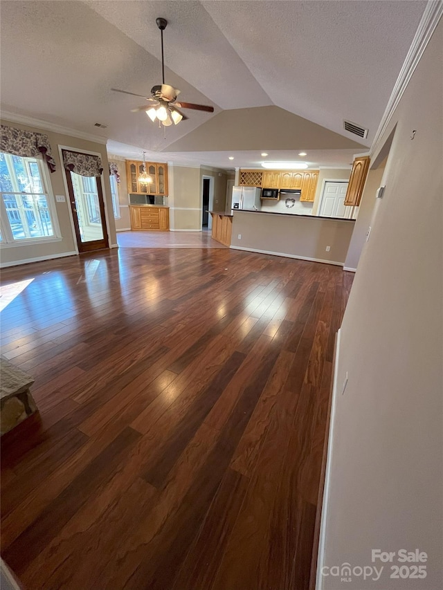 unfurnished living room with a textured ceiling, dark hardwood / wood-style floors, and vaulted ceiling