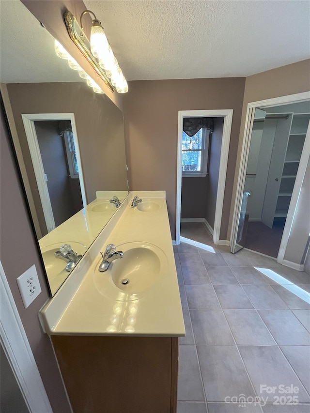 bathroom featuring tile patterned floors, vanity, and a textured ceiling