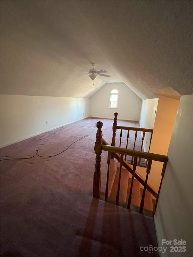 bonus room with carpet, a textured ceiling, ceiling fan, and lofted ceiling