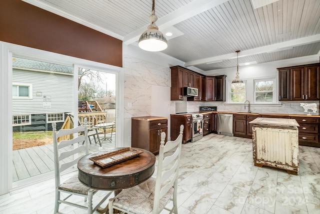 kitchen with backsplash, stainless steel appliances, and hanging light fixtures