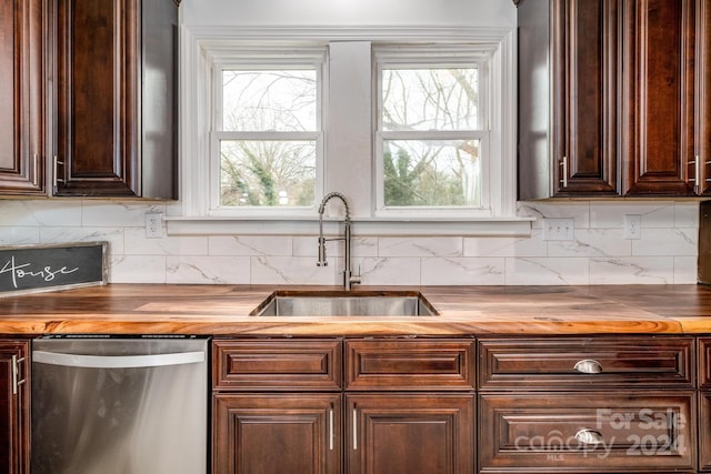 kitchen with wooden counters, tasteful backsplash, dark brown cabinetry, sink, and dishwasher