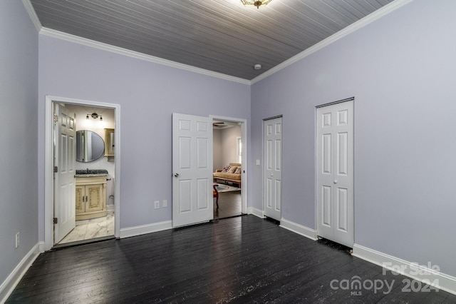 unfurnished bedroom featuring dark hardwood / wood-style flooring, connected bathroom, wooden ceiling, and crown molding