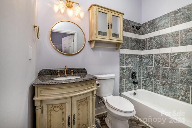 full bathroom featuring vanity, tiled shower / bath, and toilet