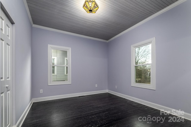 spare room featuring dark wood-type flooring and ornamental molding