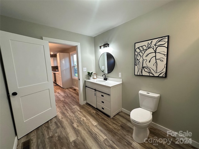 bathroom featuring hardwood / wood-style flooring, vanity, and toilet