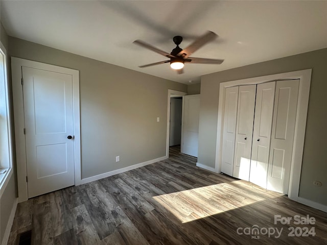 unfurnished bedroom with a closet, ceiling fan, and dark hardwood / wood-style flooring