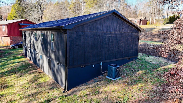 view of outbuilding featuring central air condition unit and a yard