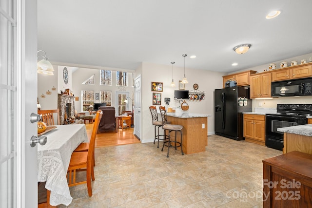 2959/2961 Bearwallow Mountain Rd, Hendersonville, NC 28792 - kitchen with a kitchen bar, hanging light fixtures, light stone countertops, and black appliances