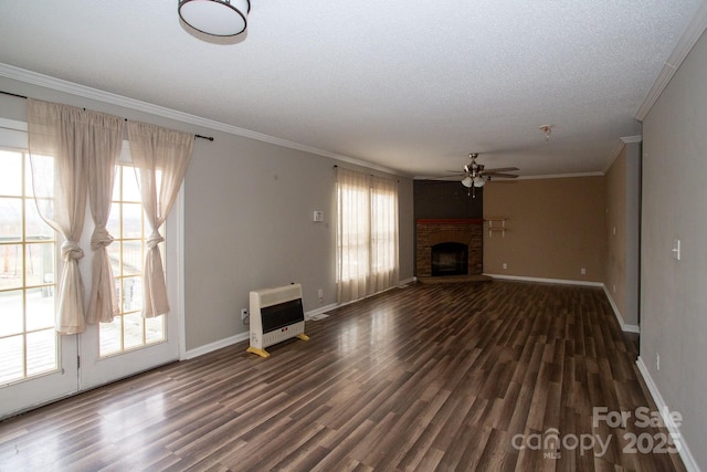 unfurnished living room with a brick fireplace, dark hardwood / wood-style floors, ornamental molding, and heating unit