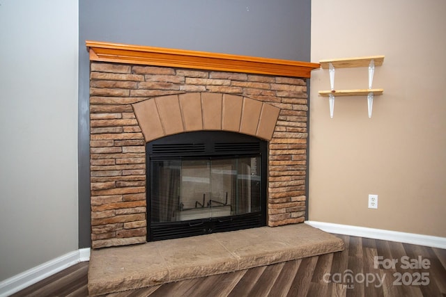 interior details with hardwood / wood-style floors and a stone fireplace