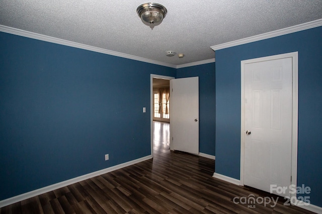 empty room featuring a textured ceiling, dark hardwood / wood-style floors, and ornamental molding