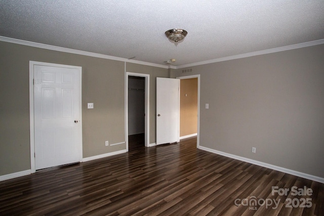 spare room with a textured ceiling, dark hardwood / wood-style flooring, and ornamental molding