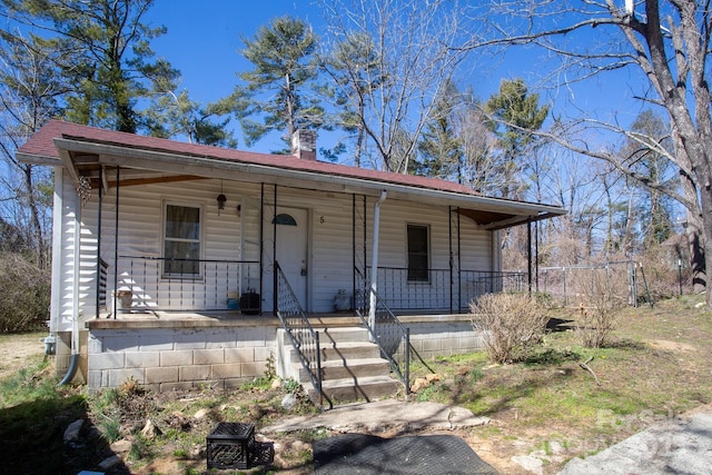 view of front of property featuring covered porch and a chimney