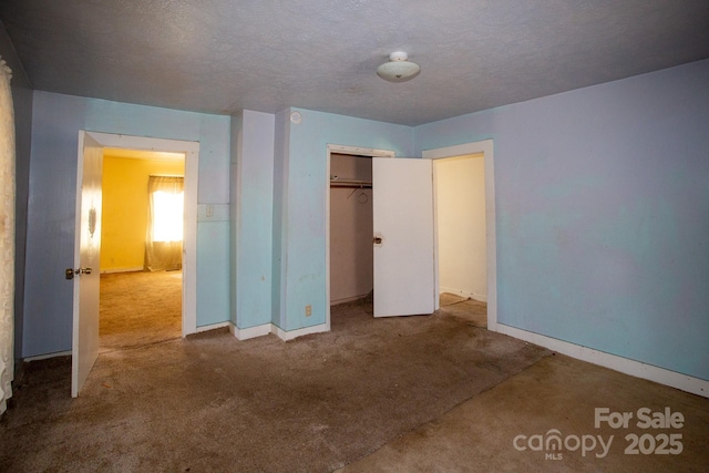 unfurnished bedroom with a closet, baseboards, carpet, and a textured ceiling