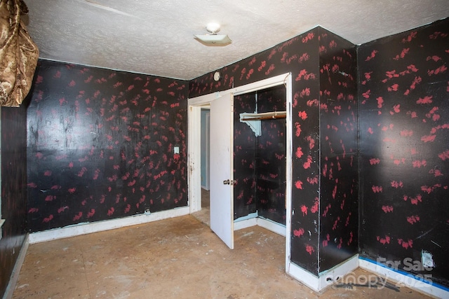 spare room featuring baseboards and a textured ceiling