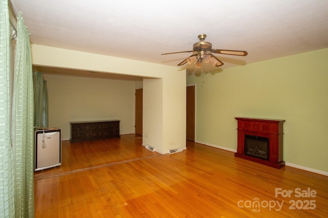 unfurnished living room with hardwood / wood-style flooring and ceiling fan