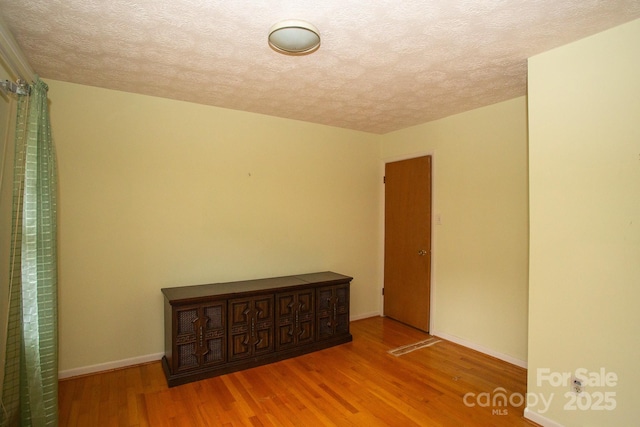 spare room with hardwood / wood-style flooring and a textured ceiling