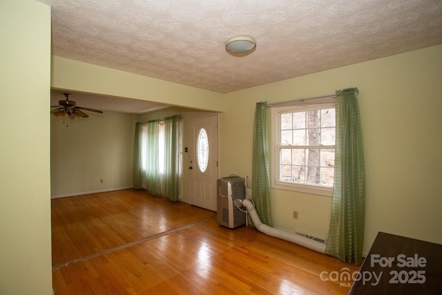 entrance foyer with hardwood / wood-style floors and a textured ceiling