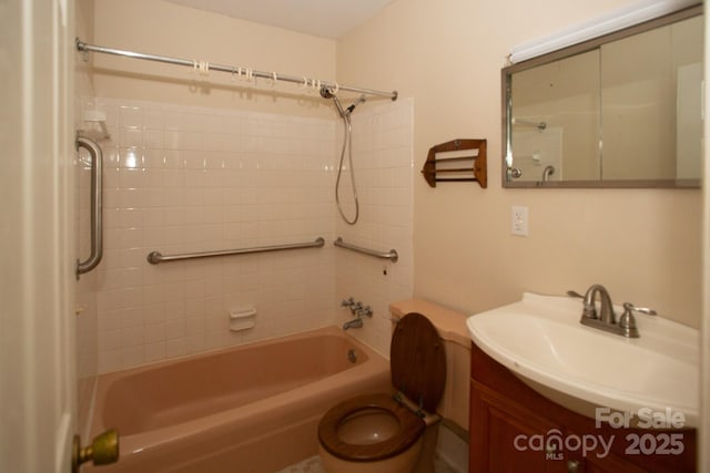 full bathroom featuring tiled shower / bath, vanity, and toilet