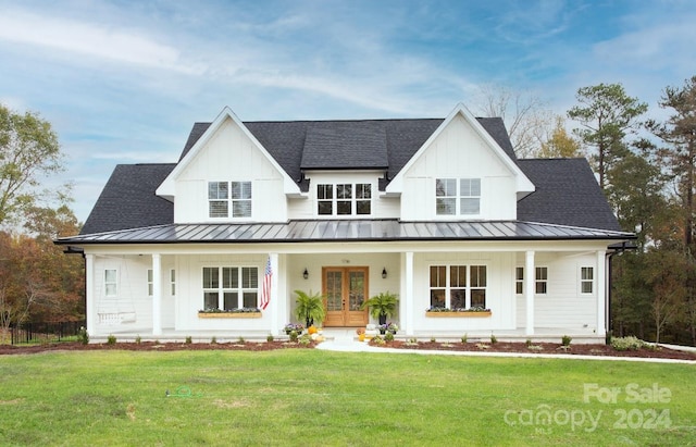 modern farmhouse with french doors, a porch, and a front yard