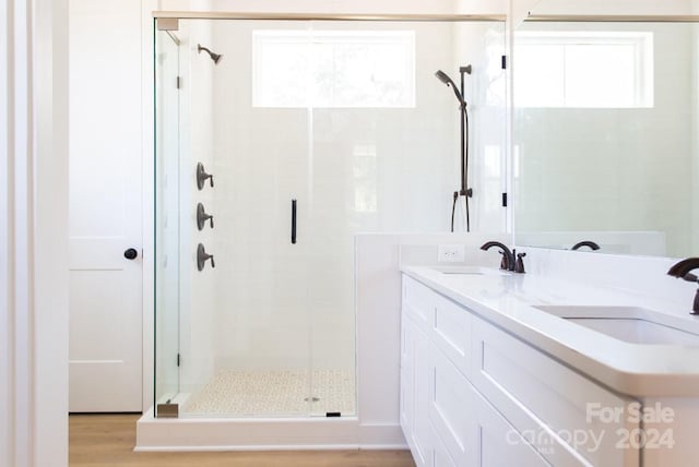 bathroom featuring a shower with door, vanity, and hardwood / wood-style flooring