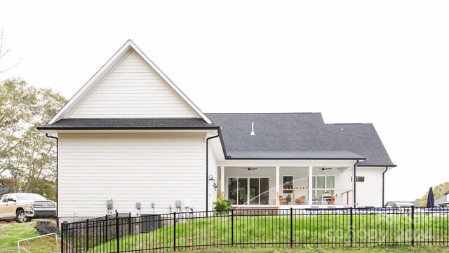 back of property featuring a lawn and ceiling fan