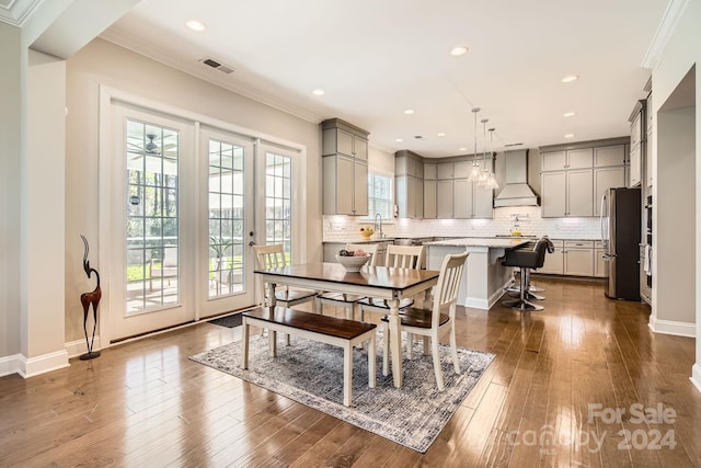 dining room featuring dark hardwood / wood-style flooring, ornamental molding, and sink