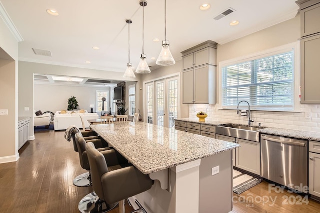 kitchen with stainless steel dishwasher, a breakfast bar, a center island, and sink