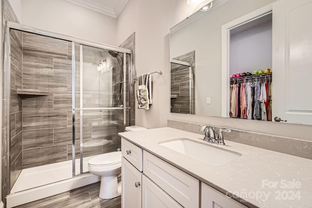 bathroom with vanity, toilet, an enclosed shower, and ornamental molding