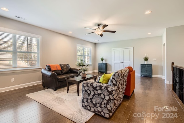 living room featuring ceiling fan and dark hardwood / wood-style floors