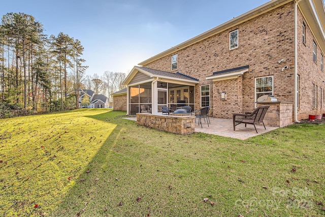 back of house featuring a sunroom, a patio, and a lawn