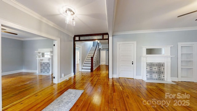 unfurnished living room featuring hardwood / wood-style flooring, a fireplace, and ornamental molding