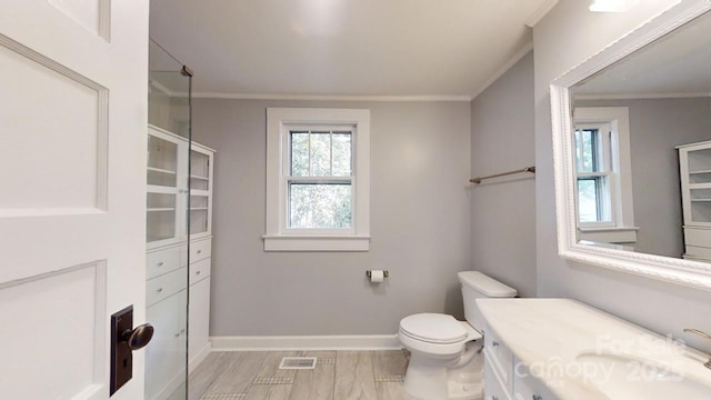 bathroom with vanity, toilet, and ornamental molding