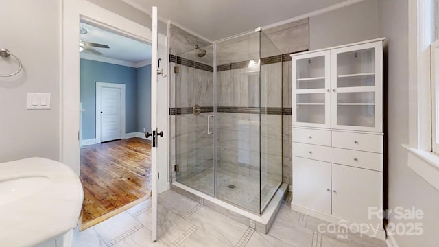 bathroom with vanity, a shower with door, ornamental molding, and ceiling fan