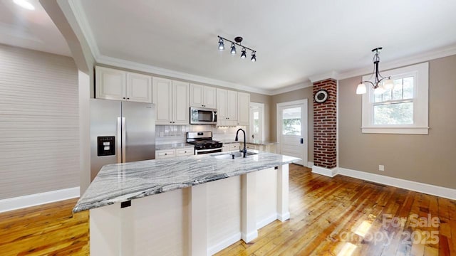 kitchen featuring white cabinets, appliances with stainless steel finishes, hanging light fixtures, and sink