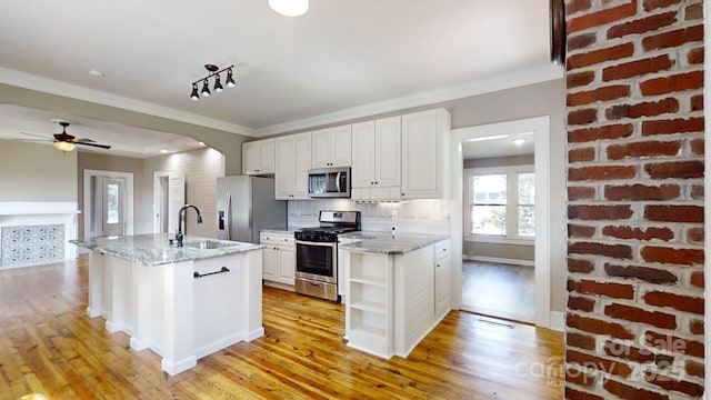 kitchen with sink, decorative backsplash, light stone countertops, white cabinetry, and stainless steel appliances