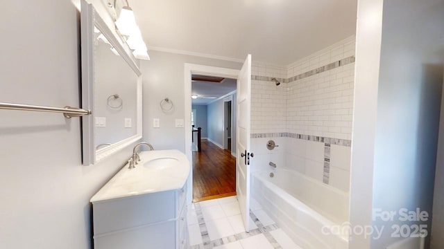 bathroom with tile patterned flooring, vanity, crown molding, and tiled shower / bath