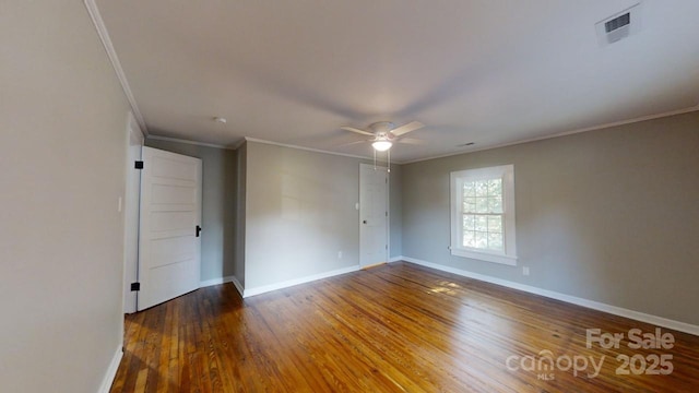 empty room featuring dark wood-type flooring, ceiling fan, and ornamental molding